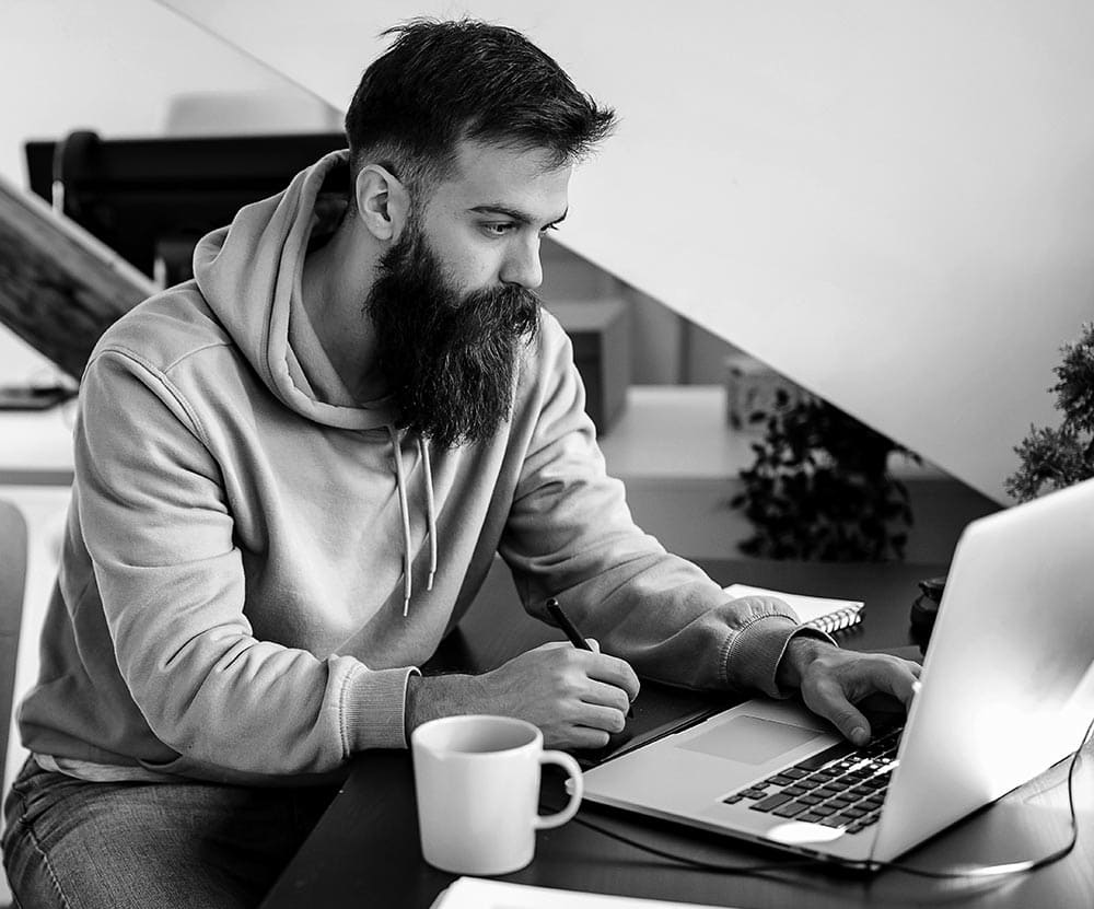 Elliott Wave International Crypto Junctures. Man looking at computer.